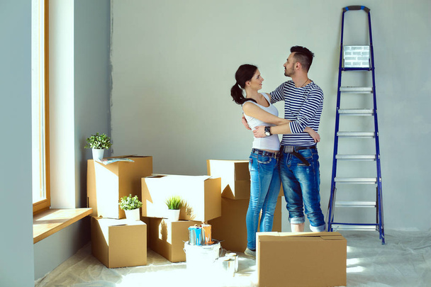 Happy young couple unpacking or packing boxes and moving into a new home. young couple - Fotó, kép