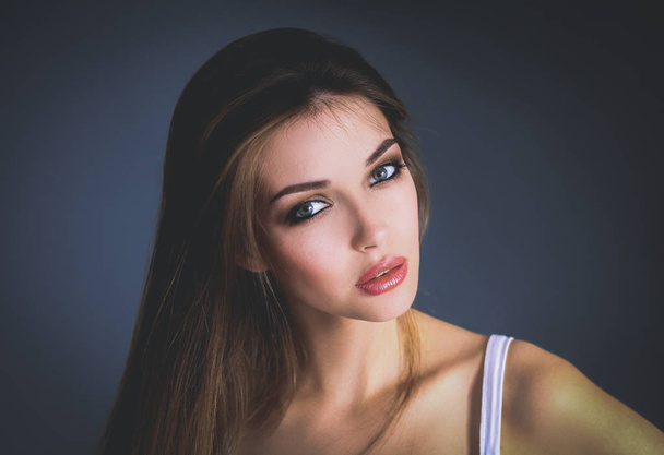Portrait of beautiful young woman face. Isolated on gray background. - 写真・画像