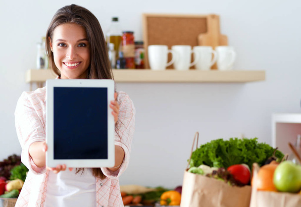 Young woman in the kitchen, using her ipad. Young woman - Foto, Bild