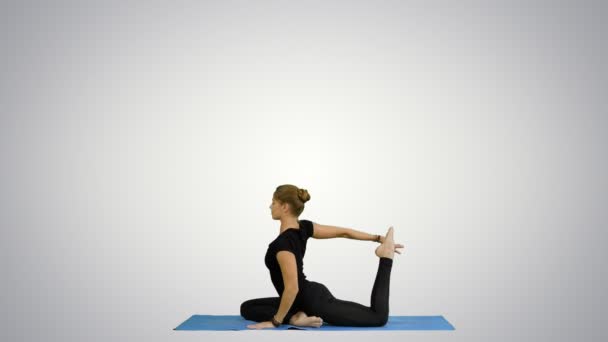 Young beautiful yoga posing on, stretching, practicing yoga on white background - Felvétel, videó