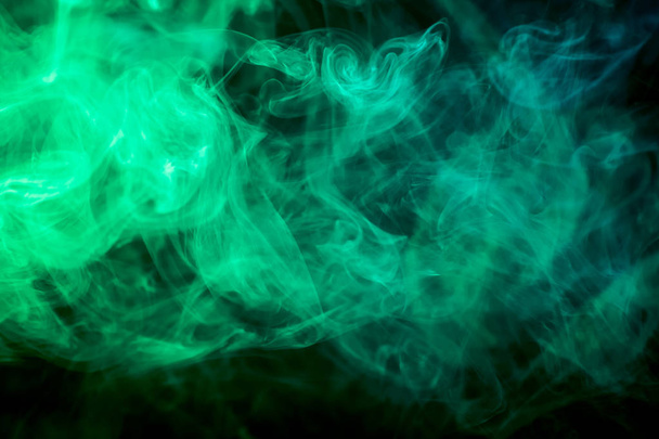 Dichter grüner Rauch auf schwarzem Hintergrund. Hintergrund der Rauchschwaden - Foto, Bild