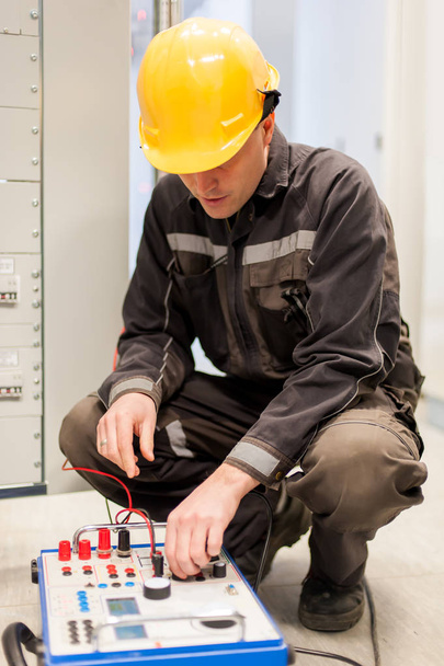 Electrician engineer tests system with relay test set equipment. Relay and protection testing - Photo, Image