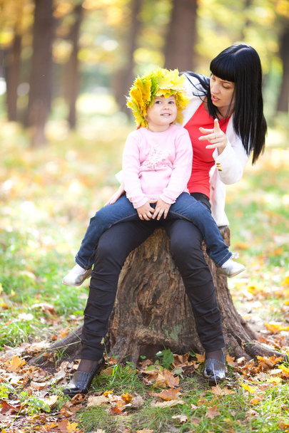 kaunis nuori äiti pitää tytärtään seppeleen vaahtera
 - Valokuva, kuva