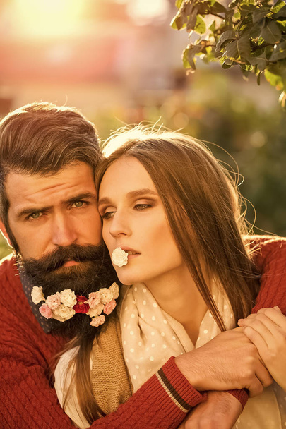 Sexy couple. Girl and man with flowers on beard - Фото, изображение