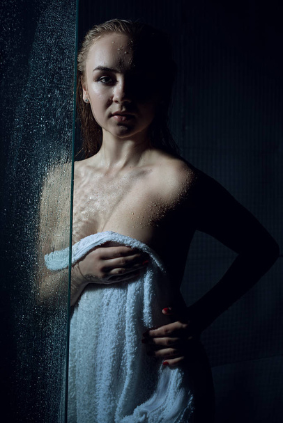 Mulher sexy envolto em uma toalha ter chuveiro no escuro quarto retrato
 - Foto, Imagem