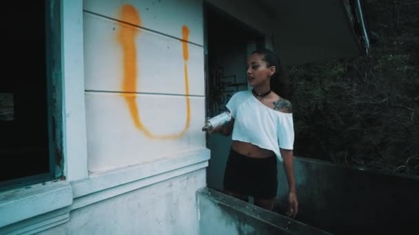 Graffiti művész lány/Graffiti művész lány festés c elhagyott épület falán. Aeroszol spray palackot permetezés színes festék szép nő. Városi szabadban művészeti koncepció - Felvétel, videó