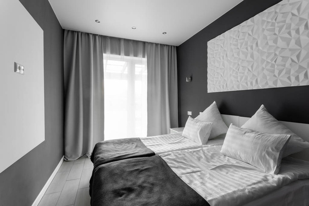 το πρωί της ημέρας. Δωμάτιο Hotel standart. μοντέρνα κρεβατοκάμαρα με λευκά μαξιλάρια. απλό και κομψό εσωτερικό. - Φωτογραφία, εικόνα