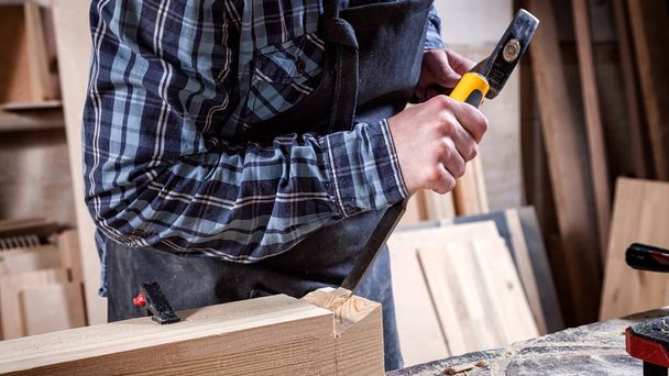 Güçlü marangoz ahşap işleme aracını kullanarak ahşap oyma iş elbiseleri içinde keski, eller yakın marangozluk ve işçilik kavramı, - Fotoğraf, Görsel