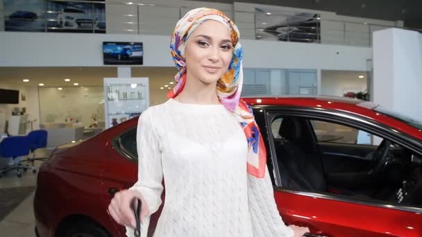 Mujer musulmana con llave del coche sobre el fondo del espectáculo de coche
 - Imágenes, Vídeo