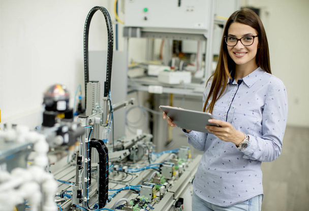 Schöne junge Frau mit digitalem Tablet in der Elektronikwerkstatt - Foto, Bild