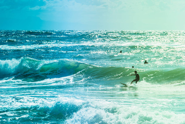 Extreme surfers riding some waves on the sea in France - Photo, Image