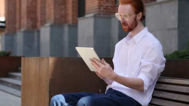 Excited Man Celebrating Success on Tabletp Sitting on Bench - Felvétel, videó