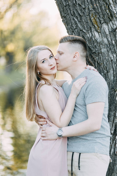 Beautiful young couple in the Park on a Sunny day, loving and happy. Walk and laugh. Pre-wedding shooting in nature. Casual style in clothing and European in processing - Zdjęcie, obraz