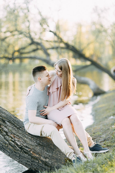 Beautiful young couple in the Park on a Sunny day, loving and happy. Walk and laugh. Pre-wedding shooting in nature. Casual style in clothing and European in processing - Foto, Imagen