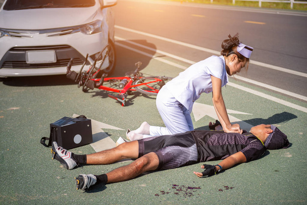 Enfermera ayudando a Emergencia CRP en bicicleta hombre en un accidente
 - Foto, Imagen