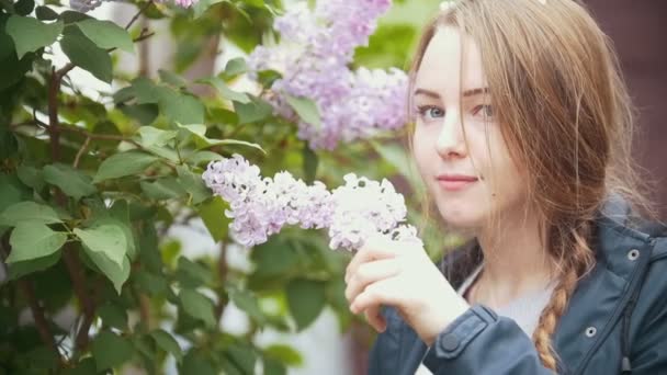 Blooming lilac, girl enjoying the smell of flowers - Footage, Video