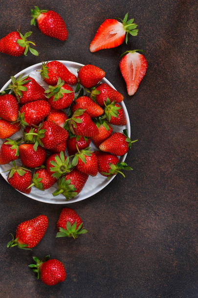 Fresh, juicy strawberries in a plate on a dark rustic background. Proper nutrition. Organic food. - Fotoğraf, Görsel