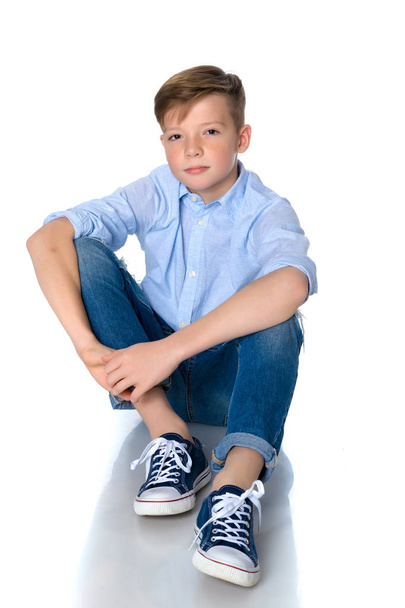 Fashionable boy teen sitting on the floor. - 写真・画像