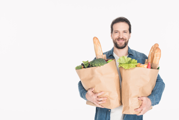 портрет улыбающегося мужчины с бумажными пакетами с продуктами, изолированными на белом
 - Фото, изображение