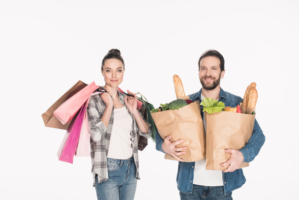 portrait of wife and husband holding shopping bags and paper packages full of food isolated on white - Photo, Image