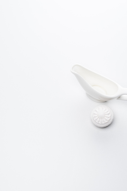 top view of white porcelain sauce boat on white tabletop - Fotoğraf, Görsel