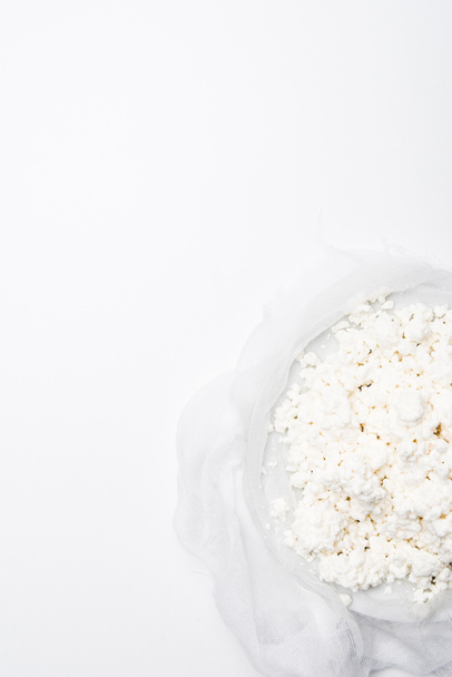 top view of homemade cottage cheese on cheesecloth on white surface - Foto, Imagen