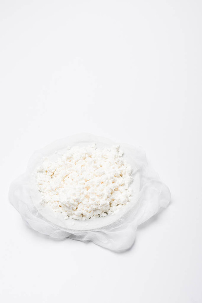 huisgemaakte kwark op kaasdoek op witte ondergrond - Foto, afbeelding