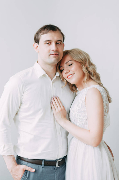 Beautiful couple in wedding photo shoot. Loft Studio in European style, bright and with large Windows. Loving people with happy faces. Bridal bouquet and stylish decorative. - Foto, Imagem
