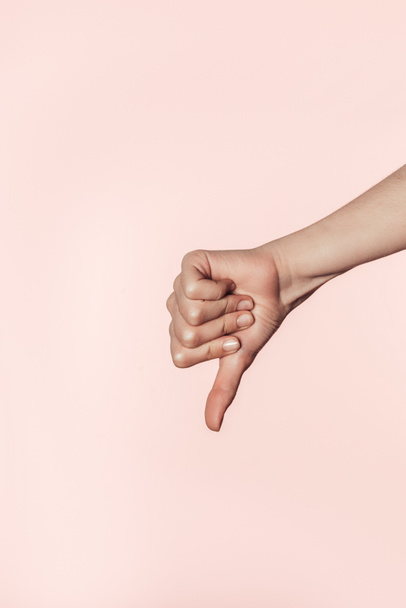 ピンクの背景に分離されたジェスチャーを親指をやって女性のクロップ撮影  - 写真・画像