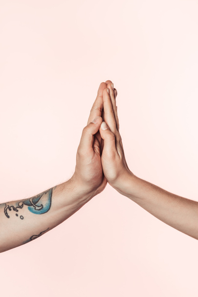 cropped shot of tattooed man and woman holding palms together isolated on pink background  - Φωτογραφία, εικόνα