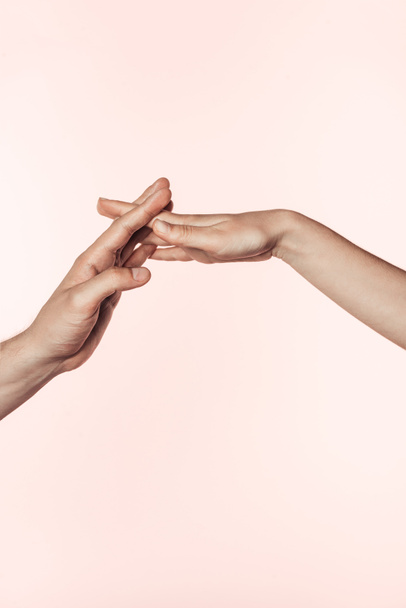 cropped image of woman and man joining hands isolated on pink background  - 写真・画像