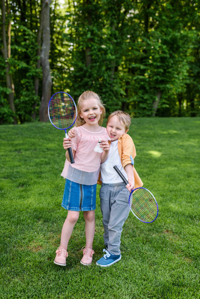 lindo feliz niños sosteniendo bádminton raquetas y Shuttlecock en parque
  - Foto, Imagen