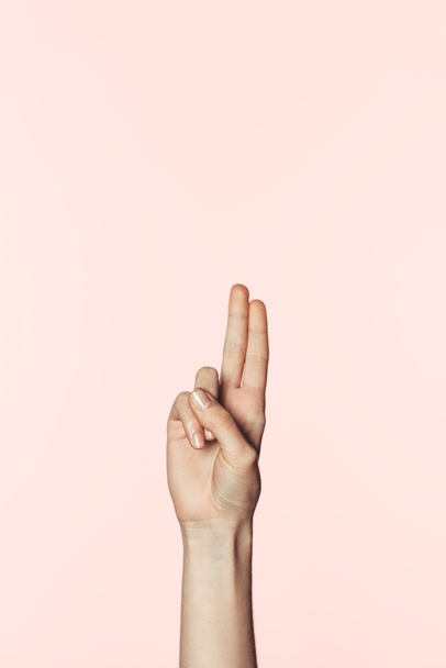cropped image of woman doing two raised fingers gesture isolated on pink background - Foto, Bild