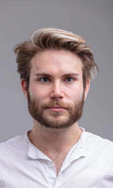Primer plano estudio retrato de un hombre barbudo joven guapo pensando en el futuro sobre fondo beige para el espacio de copia
 - Foto, Imagen