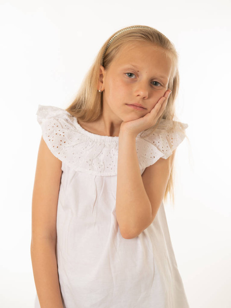 Portrait of a pretty bored, depressed, alone, tired, disappointed child resting his face on hand. Isolated white background. Human emotions, facial expressions, body language and feelings - Photo, Image