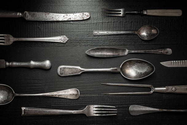 Παλιά ρουστίκ μαχαιροπίρουνα σε σκούρο φόντο ξύλινη. Κουζίνας και τροφίμων έννοια. - Φωτογραφία, εικόνα