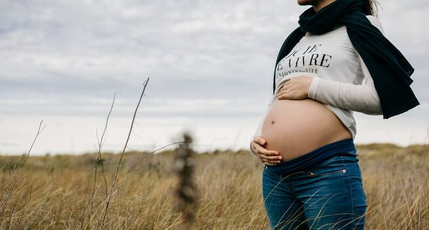 Беременная женщина ласкает свой голый животик
 - Фото, изображение