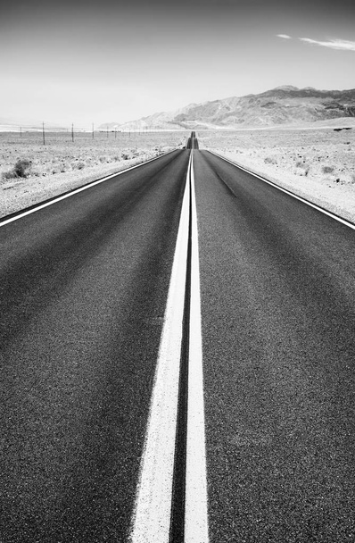 Zwart-wit beeld van een woestijn weg, focus op asfalt, reizen achtergrond, Verenigde Staten. - Foto, afbeelding