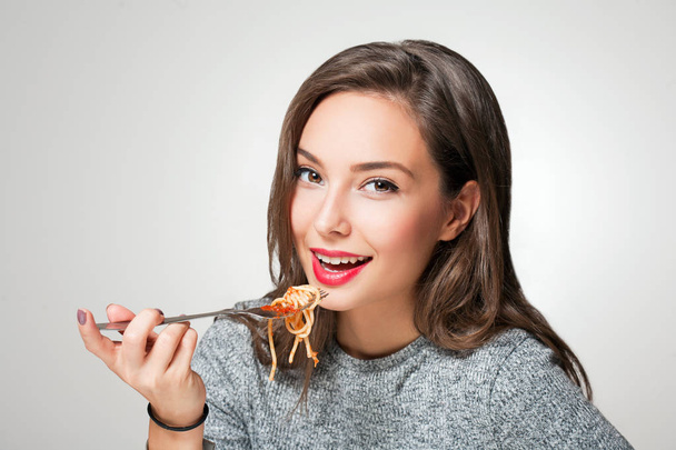 Красива молода брюнетка жінка їсть Італійська паста. - Фото, зображення