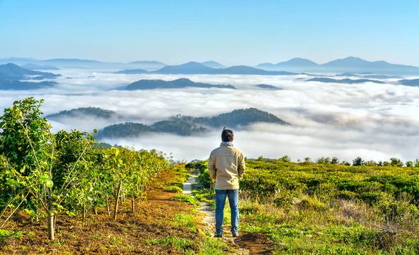 Sziluettjét fiatalember állt egy magas hegy festői vidéki szülővárosában a reggel völgyben köd homály fedi hegyeket fenyegető nagy, hullámzó festői helyszínen a natív Vietnam - Fotó, kép