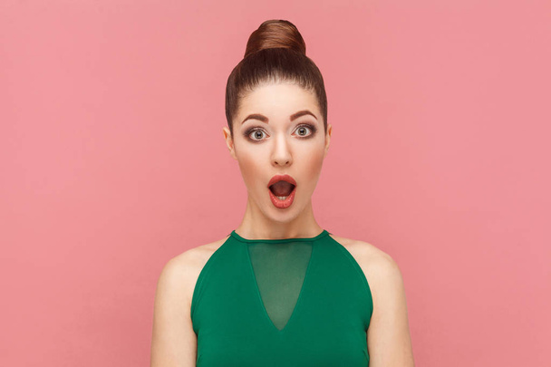 Portrait of amazement beautiful woman with opened mouth and big eyes looking at camera on pink background - Foto, immagini