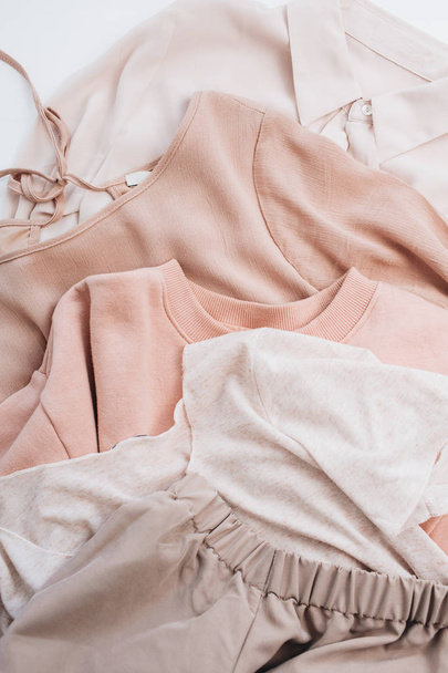 Female pale pastel pink clothes. Flat lay, top view fashion concept. - Foto, imagen