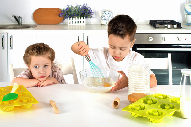 маленький мальчик и девочка готовить торт на кухне
 - Фото, изображение