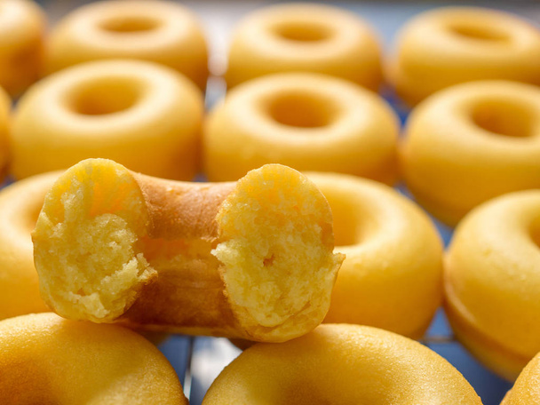 Close-up beeld van één helft op de top van de groep van gebakken boter melk donuts - Foto, afbeelding