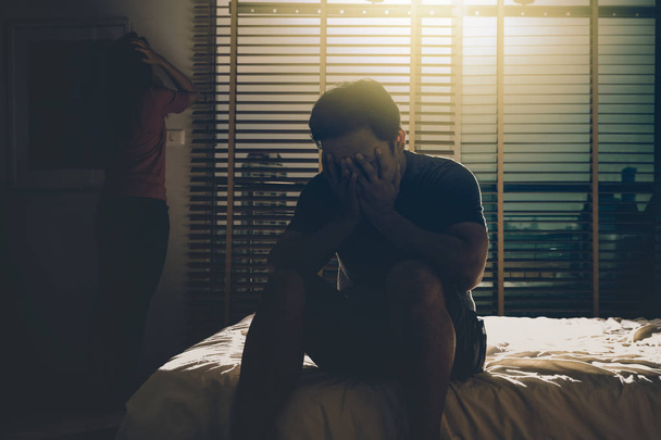 depresi pár muž a žena sedí hlavu v rukou na posteli v temné ložnici s nízké hladiny osvětlení prostředí, dramatický koncept - Fotografie, Obrázek