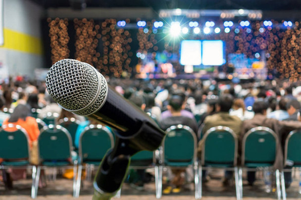 Microphone over the Abstract blurred photo of conference hall or seminar room in Exhibition Center background with Speakers on the stage and attendee background, Business meeting and education concept - Photo, Image