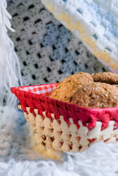 homemade oat cookies with sunflower seeds in and near red checkered basket on white and blue background - Photo, Image