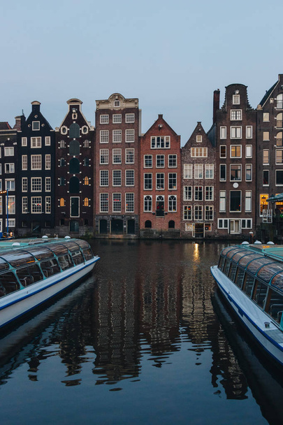 20 MAY 2018 - AMSTERDAM, NETHERLANDS: facades of ancient building above canal on twilight, Amsterdam, Netherlands - Foto, afbeelding