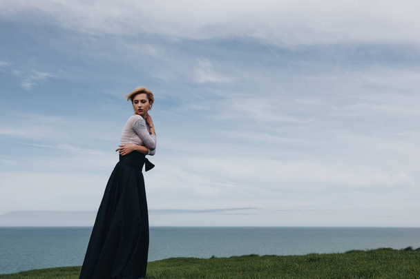 elegant stylish girl posing on cliff near sea, Etretat, Normandy, France - Fotó, kép