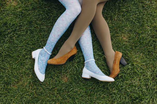 Blick auf Mädchen in trendigen Schuhen, die auf grünem Gras liegen, etretat, normandie, franz - Foto, Bild